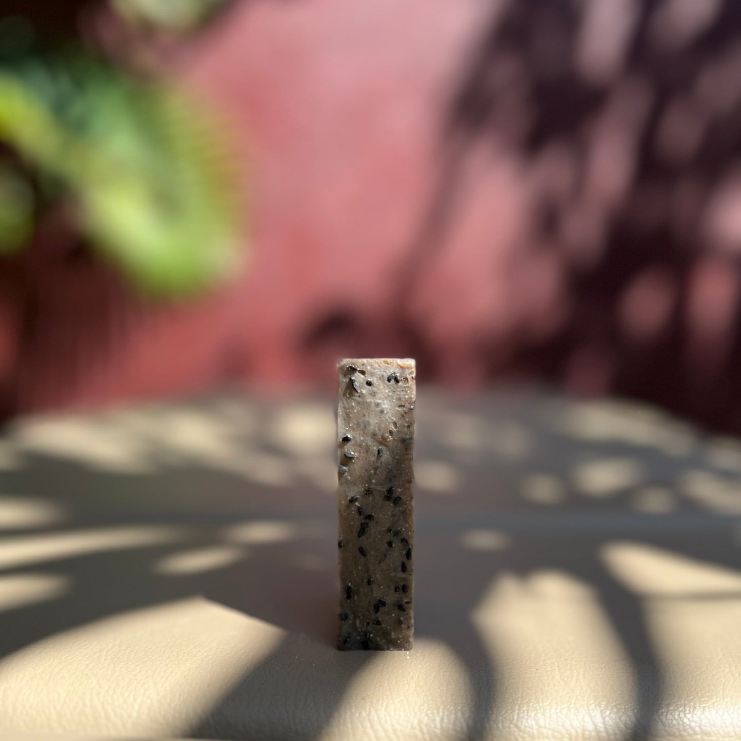 Gros plan sur la texture du savon solide surgras à l'huile de nigelle, révélant sa composition riche et apaisante.